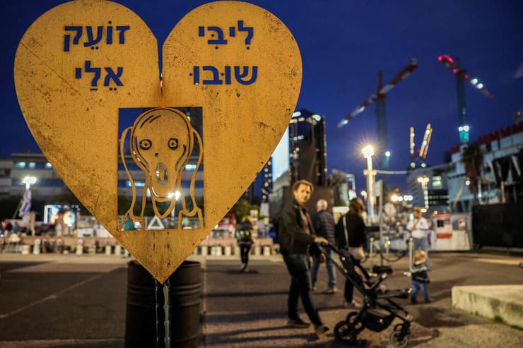 שלט בקריאה להחזזרת ה חטופים מ עזה שנתלה לקראת עצרת המחאה ב כיכר החטופים ברחבת מוזיאון תל אביב לאמנות על בסיס הציור המפורסם "הצעקה"