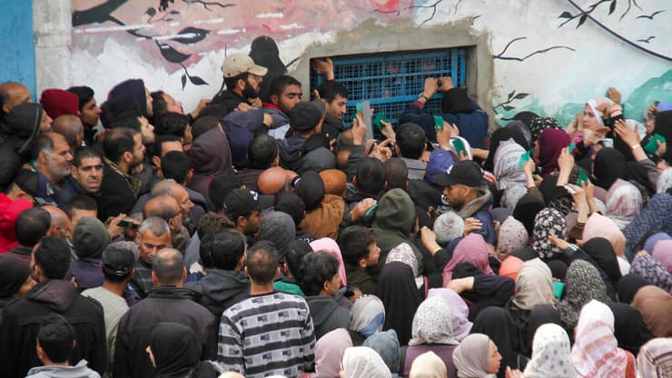 פלסטינים מתקהלים ליד מחסנים של אונר"א ב עזה