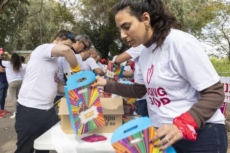 עשרות מתנדבים אורזים משלוחי מנות לנזקקים במסגרת אירוע של עמותת סח"י בפתח תקווה 