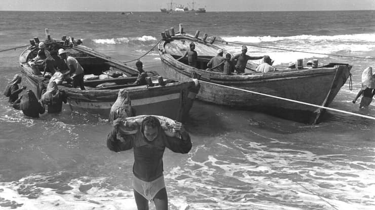 סבל סוחב שקי מלט אל החוף בנמל עזה, 1971
