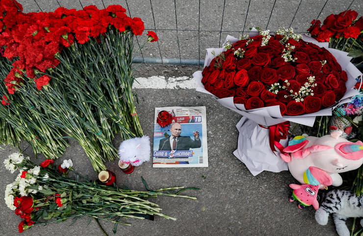 רוסיה מתקפת טרור אולם מופעים ליד מוסקבה זירת הפיגוע פרחים עיתון עם דמות פוטין והכיתוב הכוח באחדות