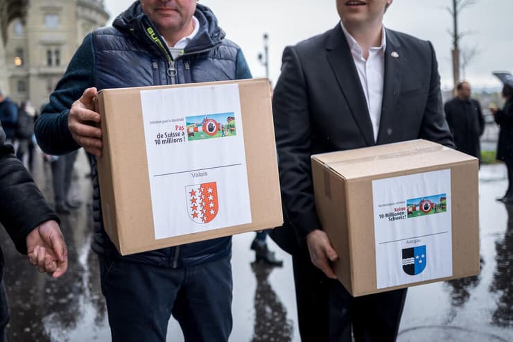 נציגים של מפלגת הימין SVP מגישים חתימות ב ברן שווייץ משאל עם על הגירה 