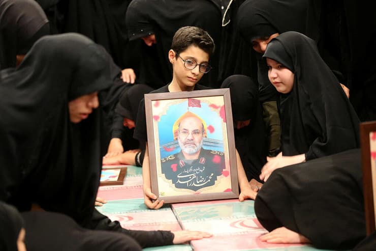 משפחתו של בכיר כוח קודס חסן מהדווי עם תמונתו בטקס תפילה ב טהרן על ארונות בכירים של משמרות המהפכה של איראן שחוסלו ב דמשק סוריה
