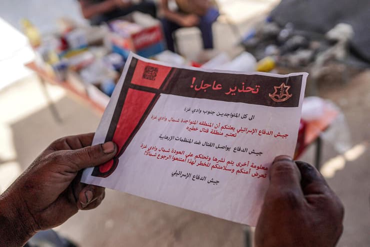 פלסטינים בדיר אל בלח מחזיקים כרוז של צה"ל