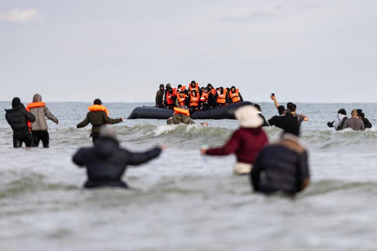 בריטניה תוכנית רואנדה מהגרים מנופפים לסירת מבריחים ב צרפת