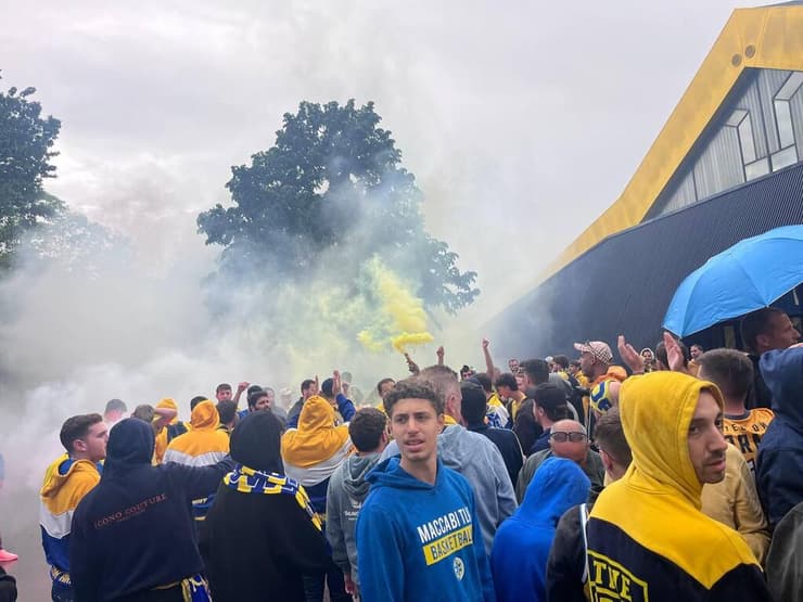 אוהדי מכבי ת"א מסתתרים מפני הגשם