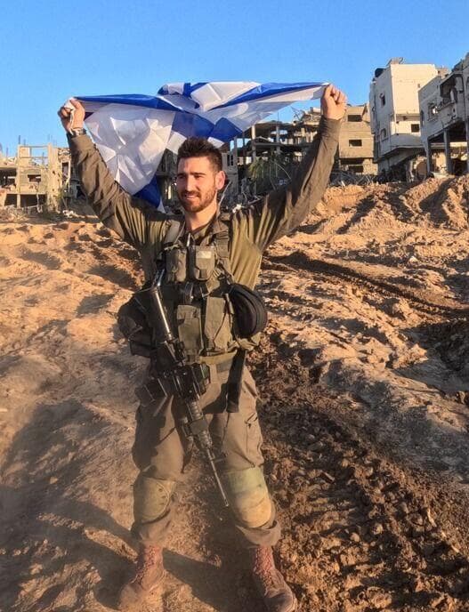 סרן (במיל') אלקנה כהן מניף את דגל ישראל ברצועת עזה