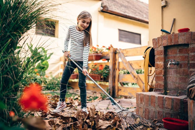 ילדה מנקה את החצר
