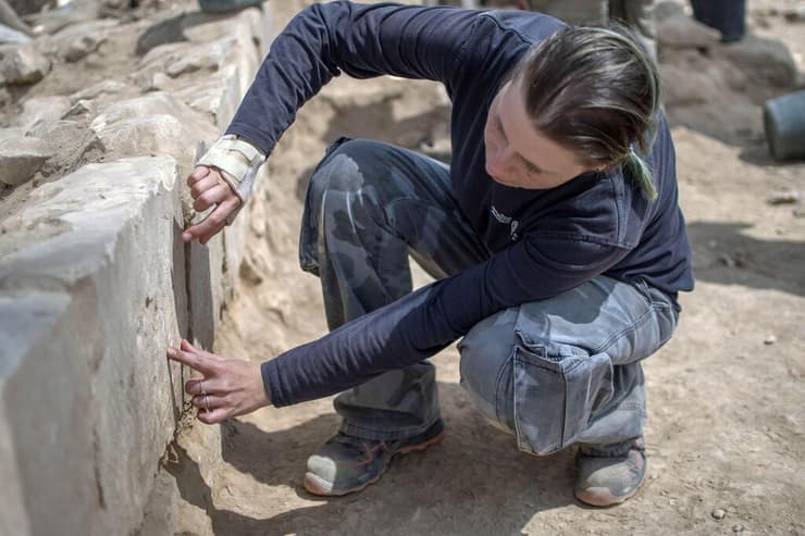הארכיאולוגית דריה אלג'ם מצביעה על דגם ספינה שהתגלה בחפירה