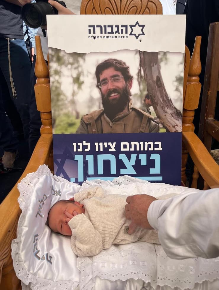התינוק שחר שמעון אשחר, לצד תמונת אביו המנוח, הרב נערן אשחר ז"ל