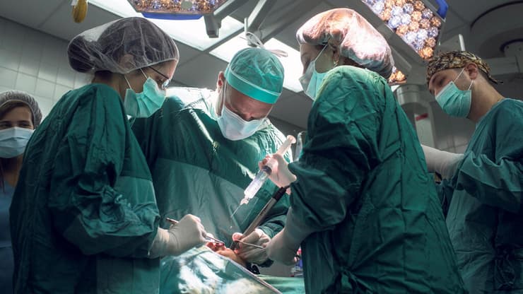 רופאים מנתחים ב חדר ניתוח