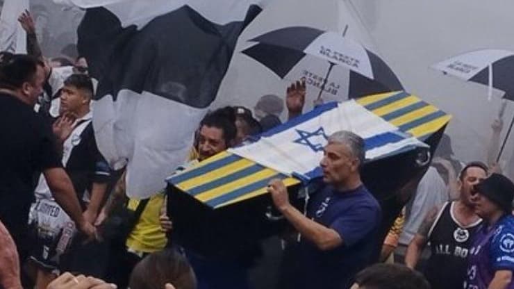 אוהדי אול בויז עם ארון קבורה ועליו דגל ישראל
