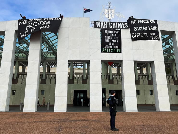 פעילים פרו-פלסטינים שטיפסו על גג ה פרלמנט ב אוסטרליה קנברה ותלו שלטים נגד ישראל מלחמה ב עזה הפגנה פרו פלסטינית פרו-פלסטינית