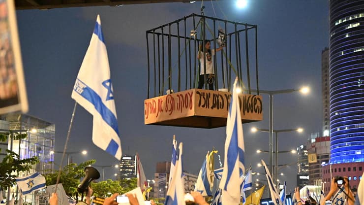 עינב צנגאוקר, אמו של החטוף מתן צנגאוקר, נכנסה בכלוב שהתרומם מעל כביש בגין