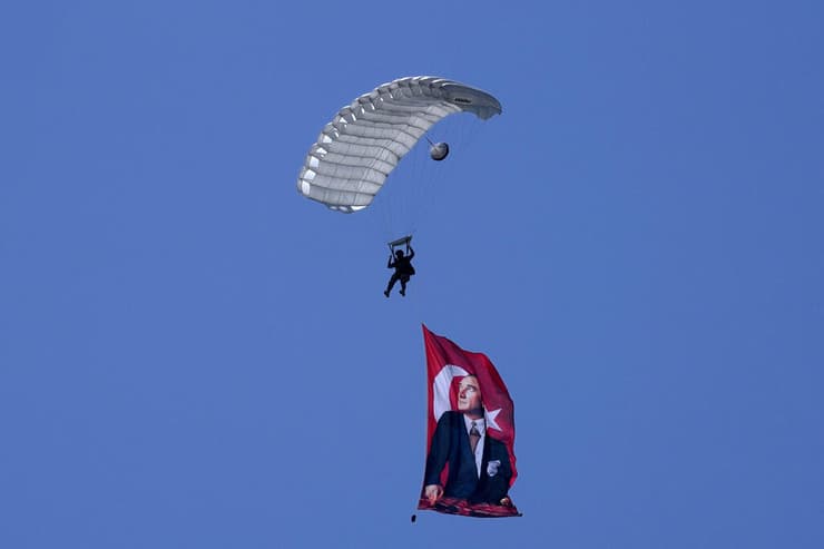חייל טורקי צונח עם דגל עם תמונת אטאטורק ב מצעד צבאי בחגיגות ב צפון קפריסין בחלק הטורקי של ניקוסיה לציון 50 שנה פלישת טורקיה לאי 20 ביולי