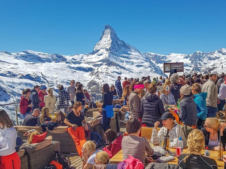 תיירים בצרמט שבשווייץ על רקע הר המטרהורן