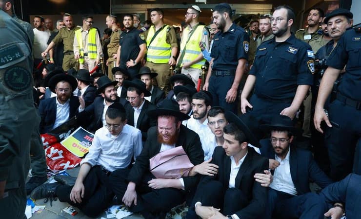 עשרות חרדים קיצוניים מפגינים נגד כנס חשיפה למתגייסים חרדים בבית החייל בתל אביב