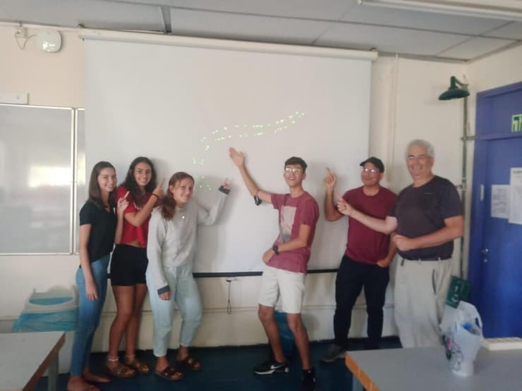 חלק מהתלמידים ופרופ׳ יורם גרשמן עם תרשים הניסוי