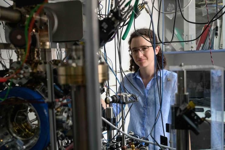 מירב פנקס והמערך הניסויי במעבדתו של פרופ' רועי עוזרי (צילום: מסע הקסם המדעי, מכון ויצמן למדע) מירב פנקס והמערך הניסויי במעבדתו של פרופ' רועי עוזרי