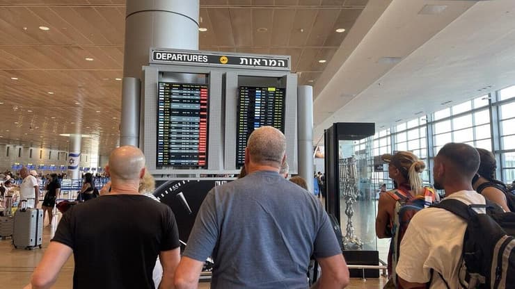 נוסעים מנסים לראות האם טיסתם נדחתה, עקב המתקפה של חיזבאללה