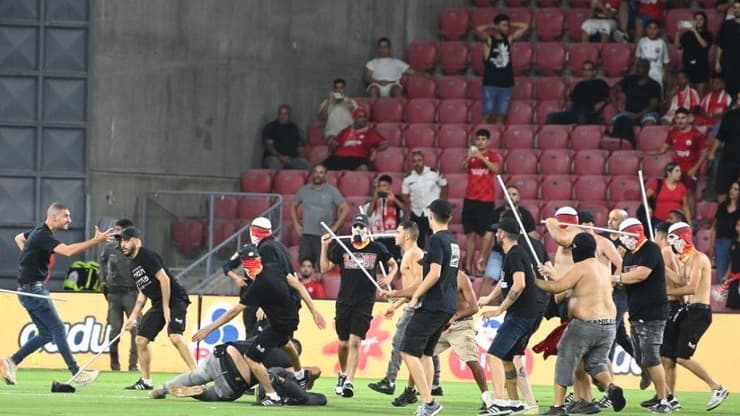 אוהדי הפועל באר-שבע פורצים לכר הדשא כדי להתעמת עם אוהדי סכנין