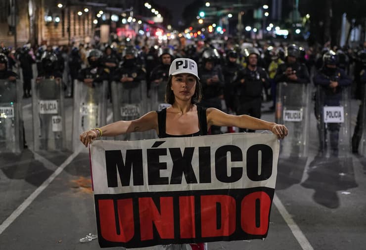 מפגינה ושוטרים, בלילה האחרון במקסיקו סיטי. מחוקק נעדר - והרוב הובטח (צילום: AP Photo/Felix Marquez) מקסיקו מפגינים נגד אישור הרפורמה המשפטית רפורמה משפטית מהפכה משפטית