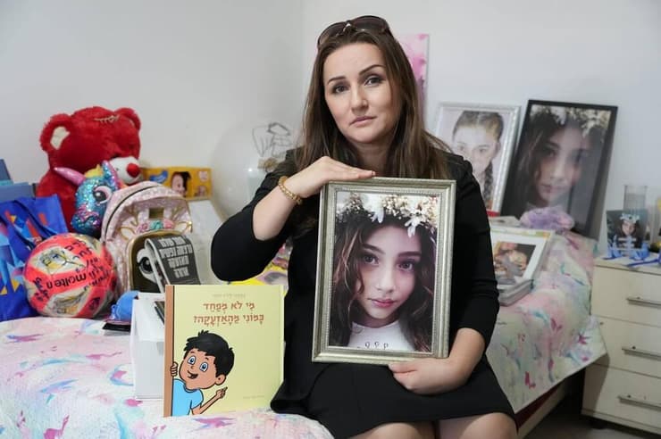"נקלענו לסרט אימה". מננה עם תמונתה של תמר והספר (צילום: תומר שונם הלוי) מננה אמא של תמר טורפיאשוילי