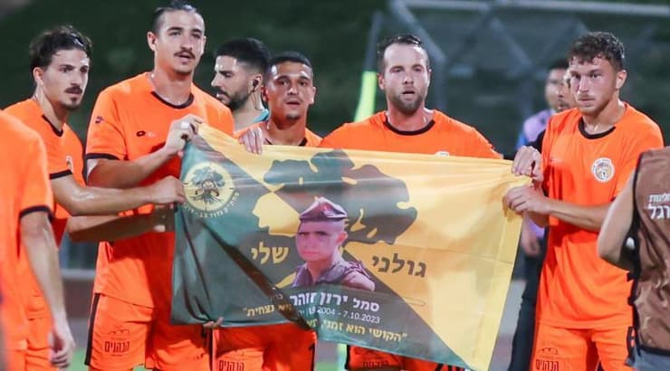 שחקני כפר שלם חוגגים עם תמונתו של ירון זוהר ז"ל (שחר גרוס) שחקני כפר שלם חוגגים עם תמונתו של ירון זוהר ז"ל