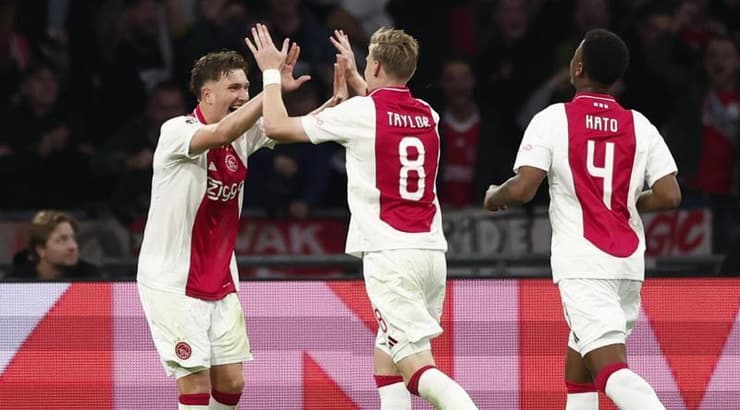 שחקני אייאקס חוגגים את השלישי (רויטרס) שחקני אייאקס חוגגים את השלישי