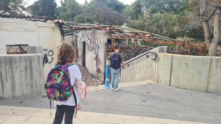 ילדיהם של עטר ועילם מאור צופים בהרס שהמחבלים זרעו בקיבוצם 