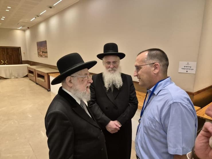 בכניסה לקלפי, הרב הראשי לשעבר עם בנו המועמד, בשיחה עם רן קוניק
