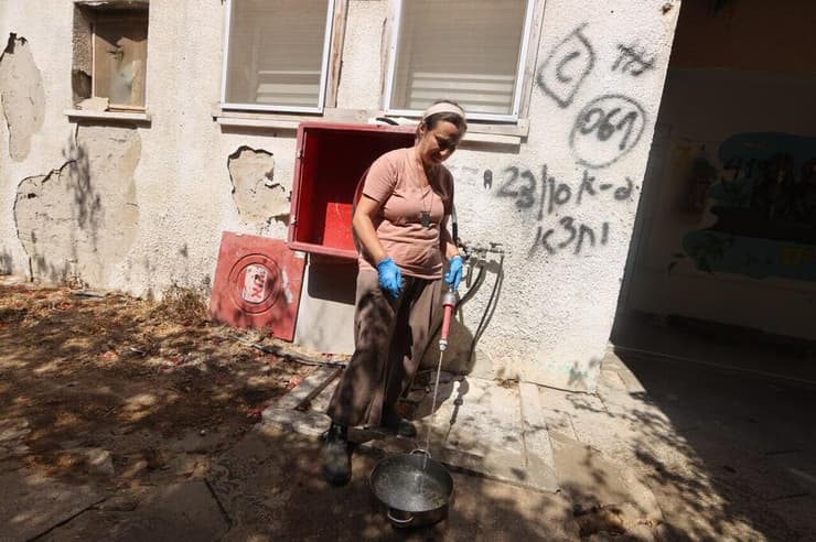 ילנה טרופנוב דואגת גם למים לחתולי הקיבוץ (צילום: גדי קבלו) ילנה טרופנוב דואגת גם למים לחתולי הקיבוץ