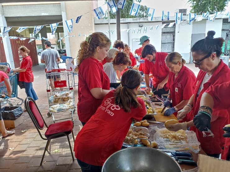 מתנדבי עמותת "מאיר פנים" אורזים מזון לחיילים ולמפונים (צילום: באדיבות עמותת "מאיר פנים") מתנדבי עמותת "מאיר פנים" אורזים מארזי חג לנזקקים