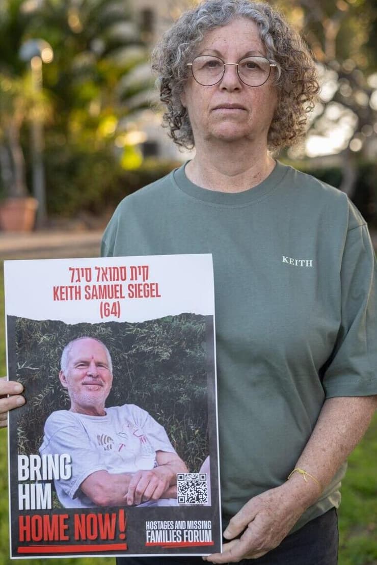 אביבה סיגל ששוחררה מהשבי עם תמונתו של בעלה קית' 