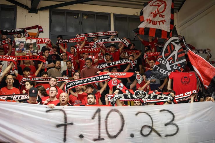 אוהדי הפועל ירושלים עם שלט זיכרון ל-7 באוקטובר