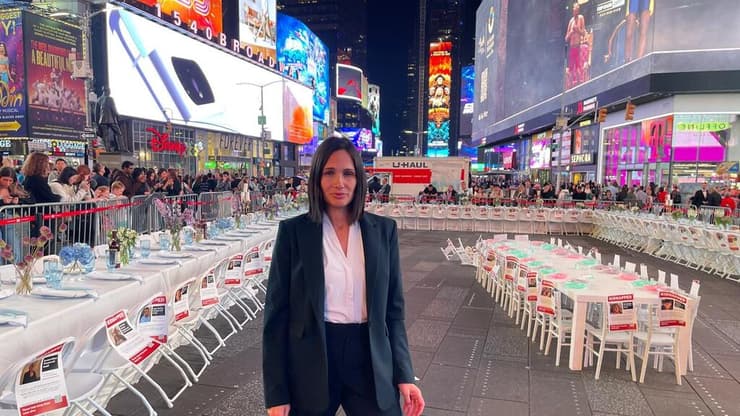 שוסטר עם מיצג שולחן השבת לשחרור החטופים בטיימס סקוור