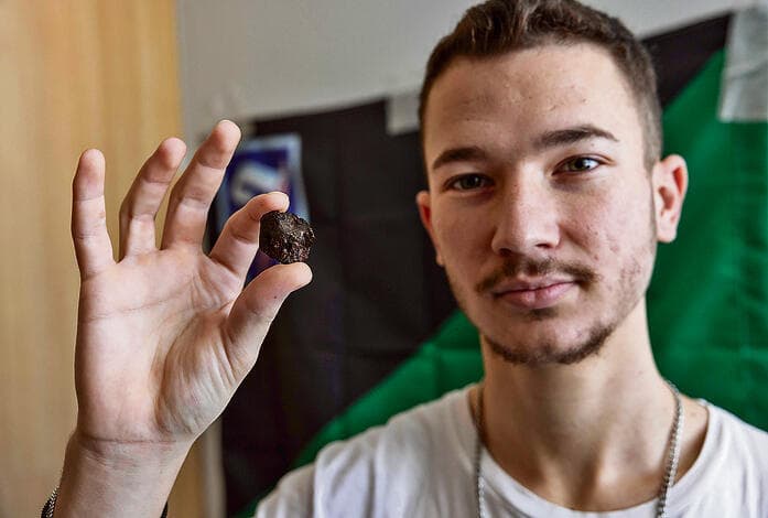 התותחן איתן רקח עם רסיס המתכת שפגע מילימטרים מעמוד השדרה שלו (צילום: טל שחר) yk14097969