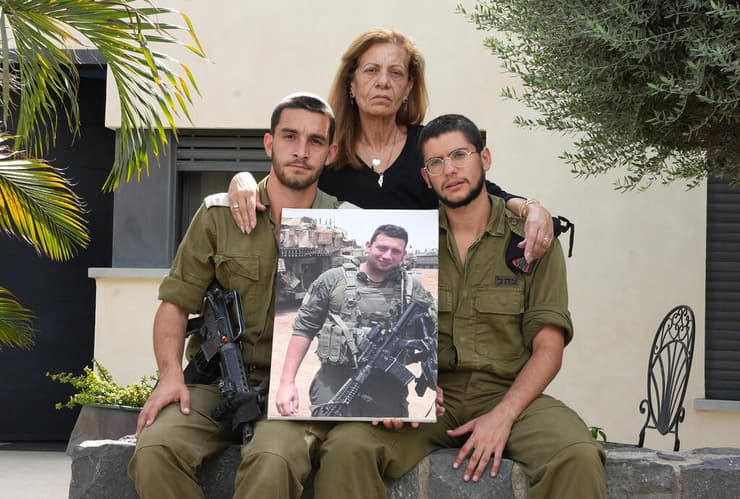 מימין: טען הטנק סמל יובל הררי, סמדר לוגסי וסגן טוביה וינברגר עם תמונתו של איליי ז"ל (צילום: אפי שריר) סמדר לוגסי, טוביה וינברגר ויובל הררי שהתראיינו על איליי לוגסי שנהרג