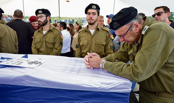 רוכן על ארונו של איתי. "רגעי השבירה הם כשאני חושב על מה שלא יקרה, חתונות, נינים" | צילום: שאול גולן yk14123984