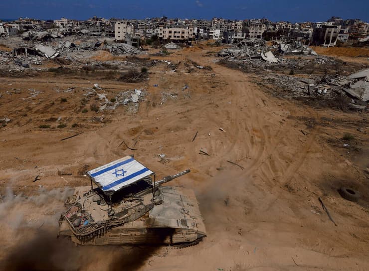 עם ישראל חי. טנק עם דגל ישראל על הצריח, מול הבתים החרבים ברצועת עזה (צילום: זיו קורן) yk14125612