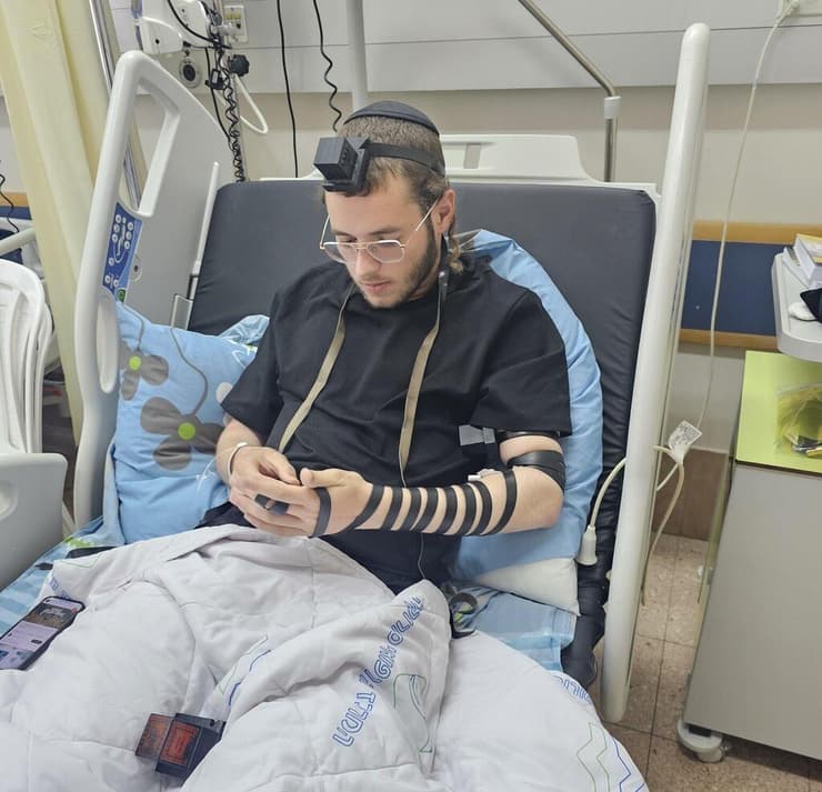 מניח תפילין בסורוקה (צילום: מתוך חשבון ה-X של חיים טרייטל) מניח תפילין בבית החולים