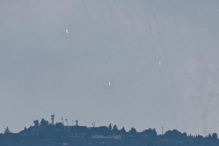 שיגורי רקטות אתמול במטח לעבר הקריות וחיפה, בצילום מאזור הגבול (צילום: REUTERS/Thomas Peter) יירוט יירוטים מלחמה מלחמת חרבות ברזל חיצי הצפון ארגון טרור חיזבאללה לבנון