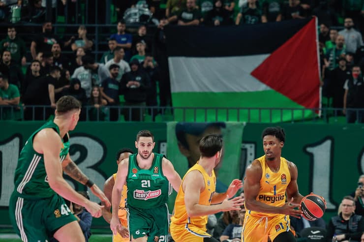 שחקני מכבי ת"א ופנאתינייקוס על רקע דגל פלסטין