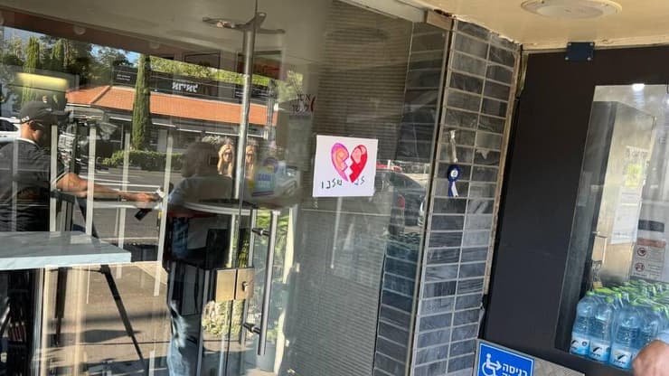 נרות זיכרון לזכרו של זיו בלפר ז״ל שנרצח מנפילת רקטה בנהריה, שהונחו על פתח בית הקפה בבעלותו