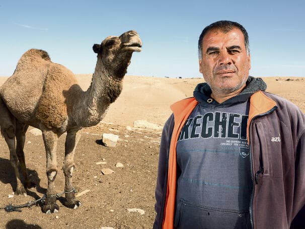 עיסא עיסמאיל אחמד ואחת הנאקות. "אני לא זז מהבית, למדתי שאסור לי לצאת עם העדר" (צילום: שאול גולן) yk14150004
