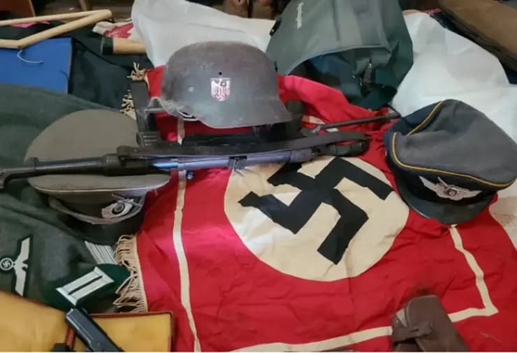 דגל נאצי, רובה וקסדות שנמצאו בבית