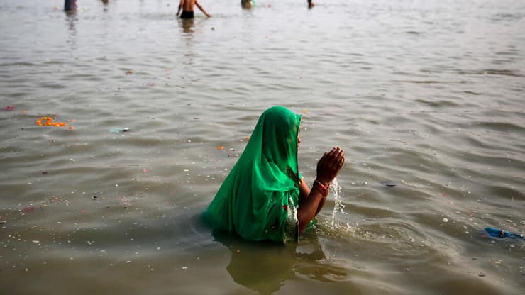 אישה הינדואיסטית מתפללת בנהר הגנגס (צילום: AP) אישה הינדואיסטית מתפללת בנהר הגנגס