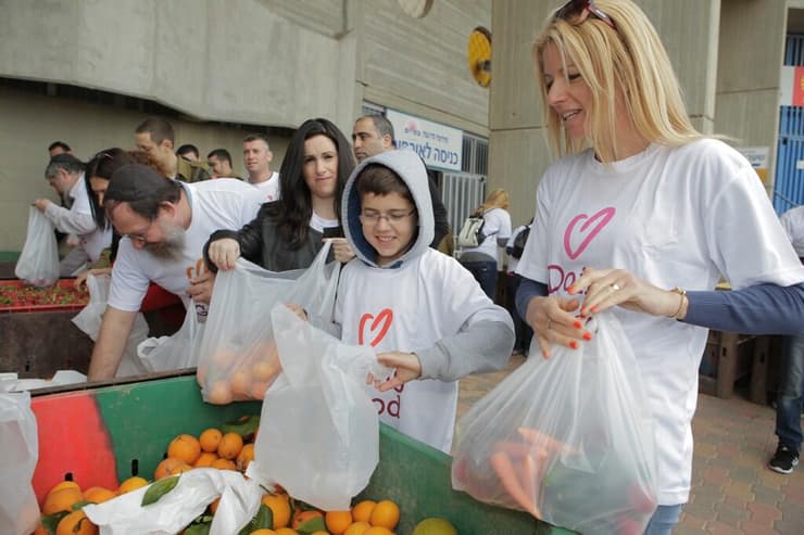 מתנדבים אורזים מצרכים לטובת מקבלי השירות של העמותה 