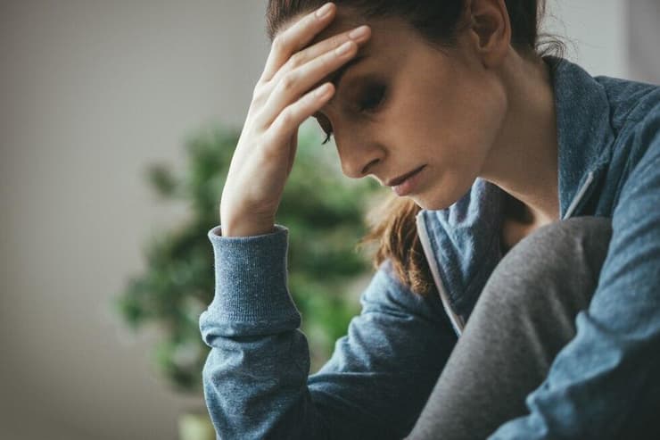 אשה עצובה עם הראש על היד