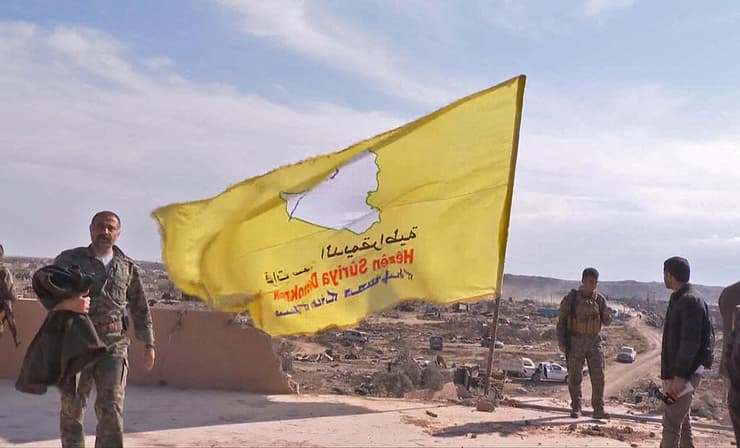 צילום: AFP כוחות סורים מניפים דגל אחרי כיבוש מוצב של דאעש